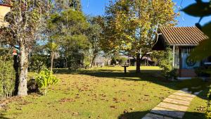 a yard with leaves on the grass next to a house at Pousada Villa do Luar by Concavus in Monte Verde