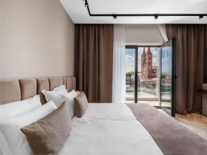 a bedroom with a large white bed and a window at Diaco Boutique Hotel in Đakovo +38 photos
