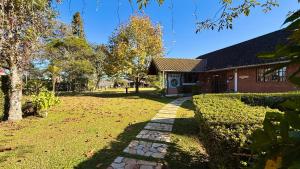a house with a walkway in front of a yard at Pousada Villa do Luar by Concavus in Monte Verde