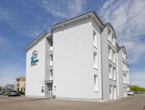 a white building with a sign on the side of it at Friends Hotel Kerpen in Kerpen