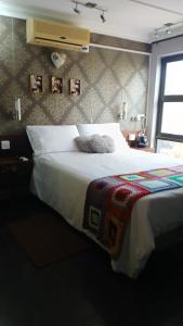 a bedroom with a bed with a blanket and a window at Urban Villa 25 in Gaborone