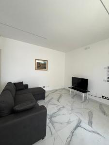 a living room with a couch and a flat screen tv at Appartamenti Gemma in Calmasino