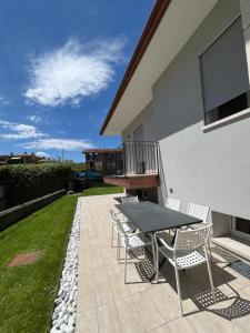 a patio with a table and chairs on the side of a house at Appartamenti Gemma in Calmasino