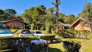 a yard with cars parked in front of a house at Pousada Villa do Luar by Concavus in Monte Verde