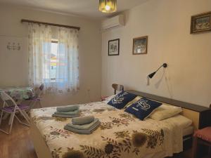 a bedroom with a bed with towels on it at APARTMAN RUŽICA in Cres +17 photos