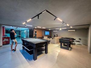 a man standing in a room with a pool table at Apto. 1 dorm. no Edf. Manhattan home service 605 in Caruaru