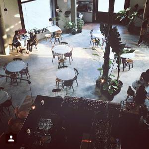 a room with tables and chairs and people sitting at tables at Spiegel Home Studio in Semarang