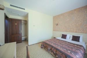 a hotel room with a bed and a door at Sunrise Villa in Baile Felix