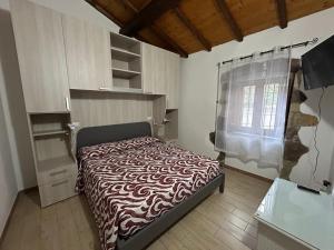 a bedroom with a bed and a window at Casa Verde con servizio gratuito E-Bike in Seneghe