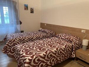 a bedroom with two beds and a night stand with a bed sidx sidx sidx sidx at Casa Verde con servizio gratuito E-Bike in Seneghe