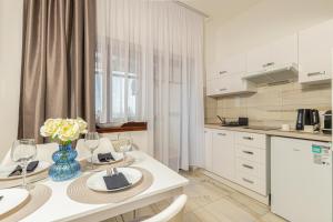 a kitchen with a table with a vase of flowers on it at Olgi Milla Villa in Balatonalmádi
