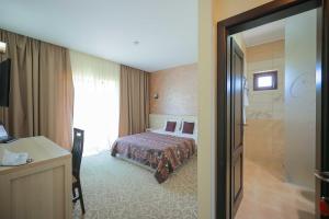 a hotel room with a bed and a bathroom at Sunrise Villa in Baile Felix