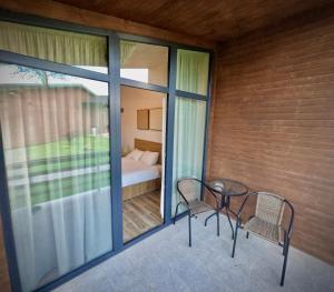 a balcony with two chairs and a table and a bed at Salt Cabins in Ocniţa