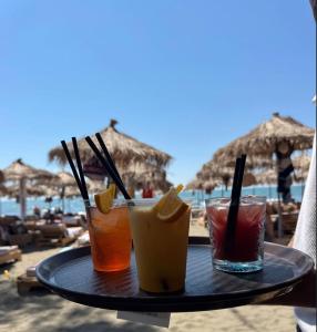 a tray with three drinks on a table at the beach at Dublex Friendly apartaments perball Rafaelos in Shëngjin