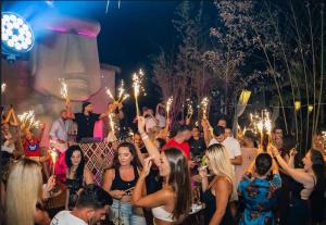 a crowd of people holding up torches at a party at Dublex Friendly apartaments perball Rafaelos in Shëngjin