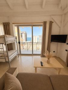 a living room with a couch and a bed and a window at Dublex Friendly apartaments perball Rafaelos in Shëngjin