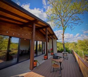 a wooden deck with tables and chairs and a tree at Salt Cabins in Ocniţa