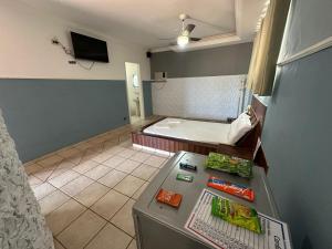 a room with a refrigerator and a bed in it at Johnnys hotel motel in Jacarèzinho