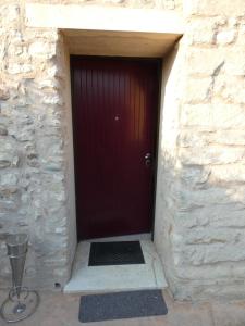 a red door in a stone building with a metal grate at Le Vele Del Cigno in Peschiera del Garda