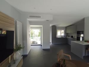 a kitchen with white cabinets and a table at Duplex Residence with Monte Carlo Sea View & 2 Terraces in Roquebrune-Cap-Martin +10 photos