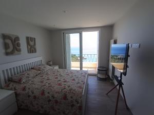 a bedroom with a bed and a flat screen tv at Duplex Residence with Monte Carlo Sea View & 2 Terraces in Roquebrune-Cap-Martin