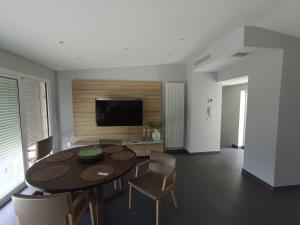 a living room with a table and chairs and a television at Duplex Residence with Monte Carlo Sea View & 2 Terraces in Roquebrune-Cap-Martin