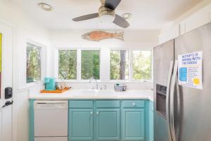 a kitchen with blue cabinets and a ceiling fan at This Home Has It All Location Amenities & More in Duck +66 photos