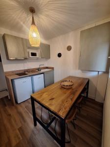 a kitchen with a wooden table in a room at Villa Pesona in Vias