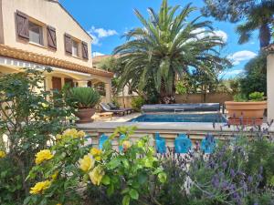 a house with a swimming pool in a garden at Villa Pesona in Vias
