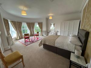 a bedroom with a bed and a desk and chairs at Sonas Mount Trenchard in Foynes +156 photos