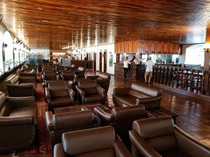 a restaurant with leather chairs and a bar at Flat 113, Hotel Cavalinho Branco in Águas de Lindoia