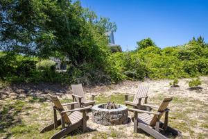 a group of three chairs sitting around a fire pit at This Home Has It All Location Amenities & More in Duck