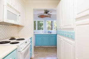 a kitchen with blue and white cabinets and a sink at This Home Has It All Location Amenities & More in Duck