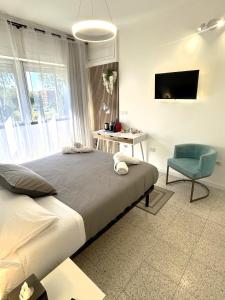 a bedroom with a bed and a chair and a television at Urban Rifugio - Camera privata con bagno vicino EUR in Rome