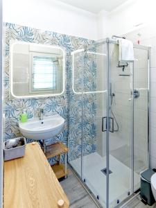 a bathroom with a glass shower and a sink at Assisi valley - Modern Apartment with Covered Parking in Bastia Umbra