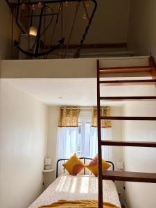 a bedroom with a bunk bed with yellow pillows at L'Échappée iodée à "La Cahute" - Rénovée, Calme & Proche Mer in Ambleteuse