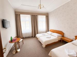a hotel room with two beds and a table at Hotel Casanova in Duchcov