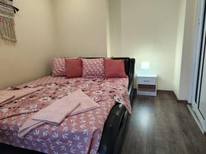 a bedroom with a bed with pink pillows at Grand Central Varna in Varna City