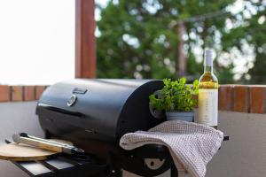 a grill with a bottle of wine and a plant at Olgi Milla Villa in Balatonalmádi