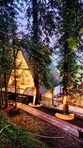 a building with a fence and trees at night at The Pinecrest in Nathia Gali