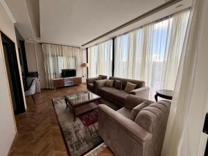 a living room with two couches and a television at The Pinecrest in Nathia Gali