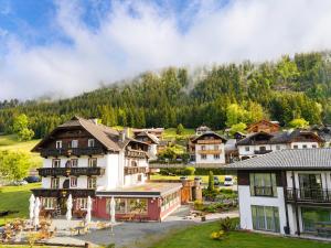 a village in the mountains with houses at Der Kaerntnerhof am Weissensee, SeeHotel & SeeApartments direkt am See in Weissensee