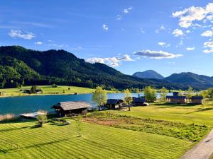 an aerial view of a resort with a lake and mountains at Der Kaerntnerhof am Weissensee, SeeHotel & SeeApartments direkt am See in Weissensee +112 photos