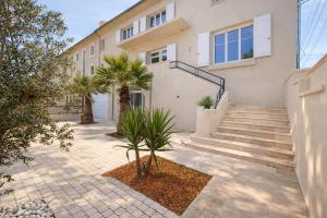 a house with stairs and palm trees in front of it at Villa Prestige - Maison d Hôtes avec Piscine, Billard et Parking Privé - Centre 5 min - Proche A7-A9 in Orange