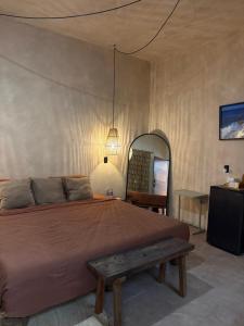 a bedroom with a large bed and a wooden bench at Ánimo Perro in Sayulita