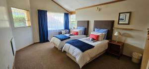 a bedroom with two beds with blue and red pillows at Applegate lodge in Clarens