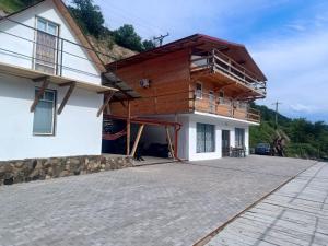 a house with a balcony on the side of it at Casa de vacanță la Dunăre in Sviniţa