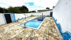 a swimming pool on a patio with a wall at Casa Gravatá Próximo ao Centro in Gravatá