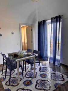 a dining room with a table and chairs on a rug at Da Feny in Massa Lubrense