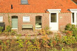 a brick house with a bench in a garden at Berend 't Boerle in Vorden